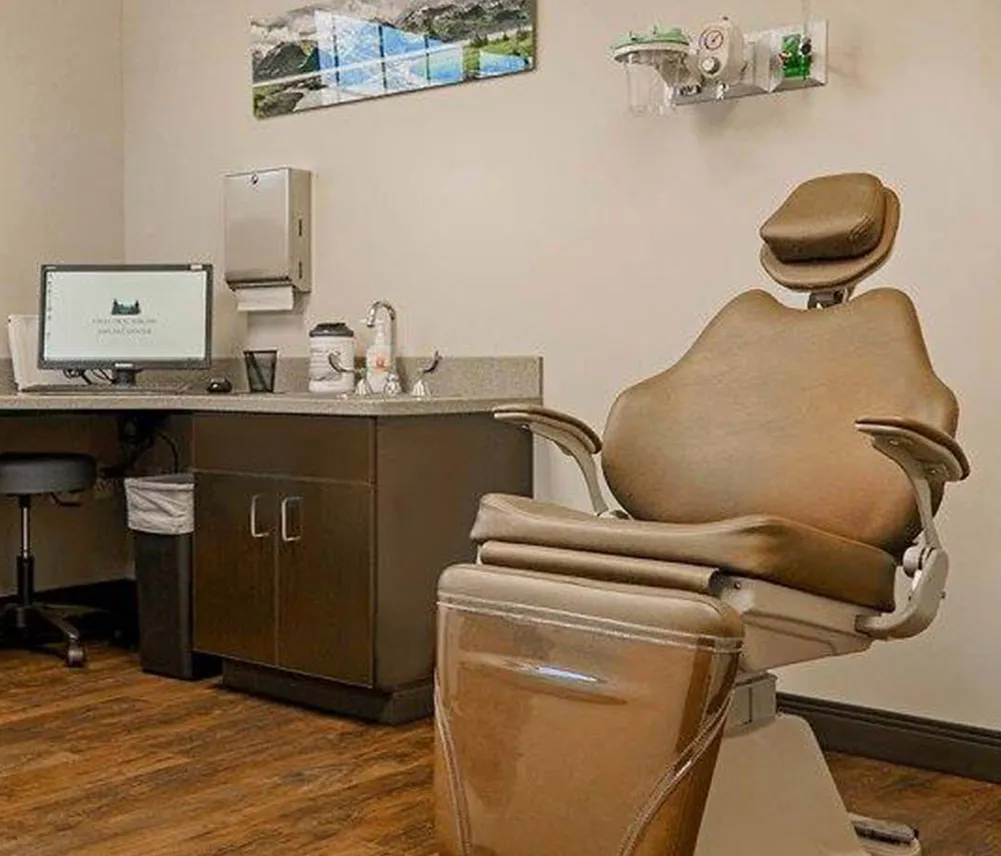 One of the exam rooms of Eagle Oral Surgery  Implant Center. Art of mountain ranges hangs on the wall of the very clean room. A comfortable dental chair sits waiting for your next visit.